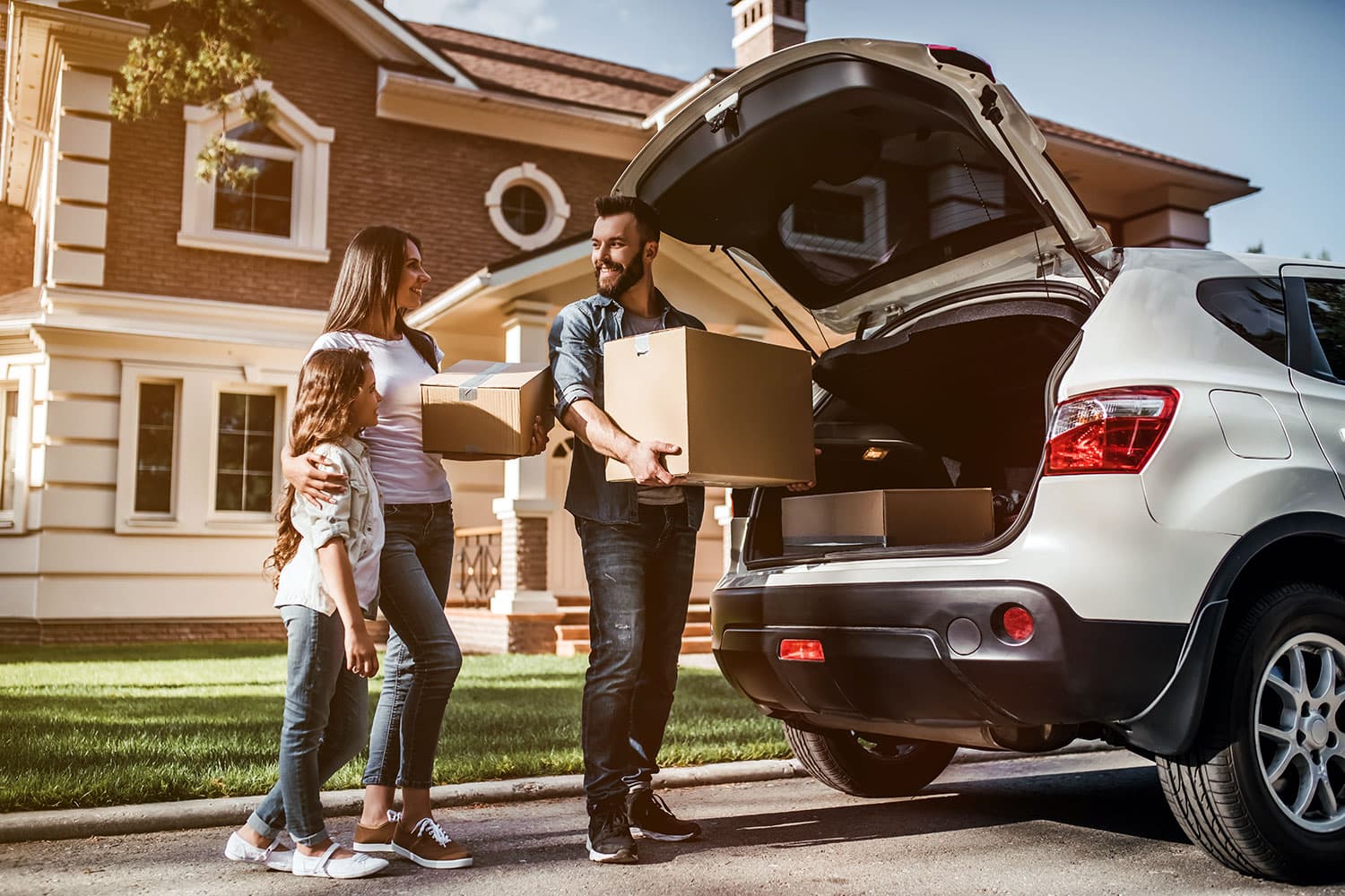 family in front of new home and car