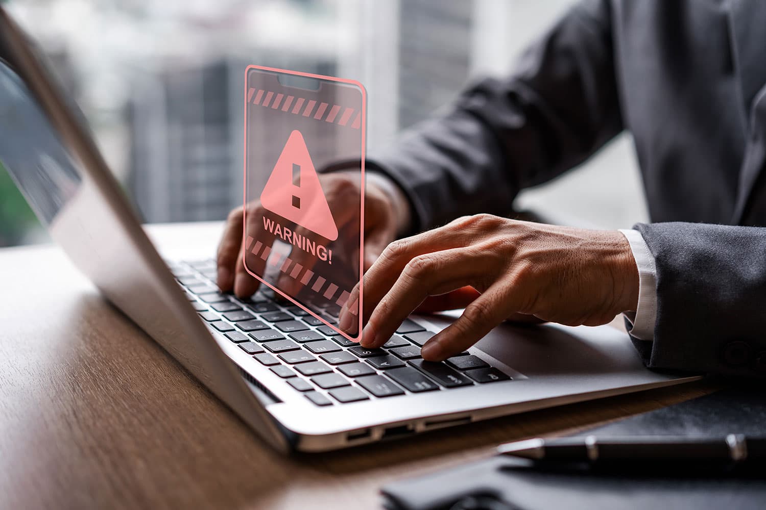 Security Alert with closeup of hands working on a laptop